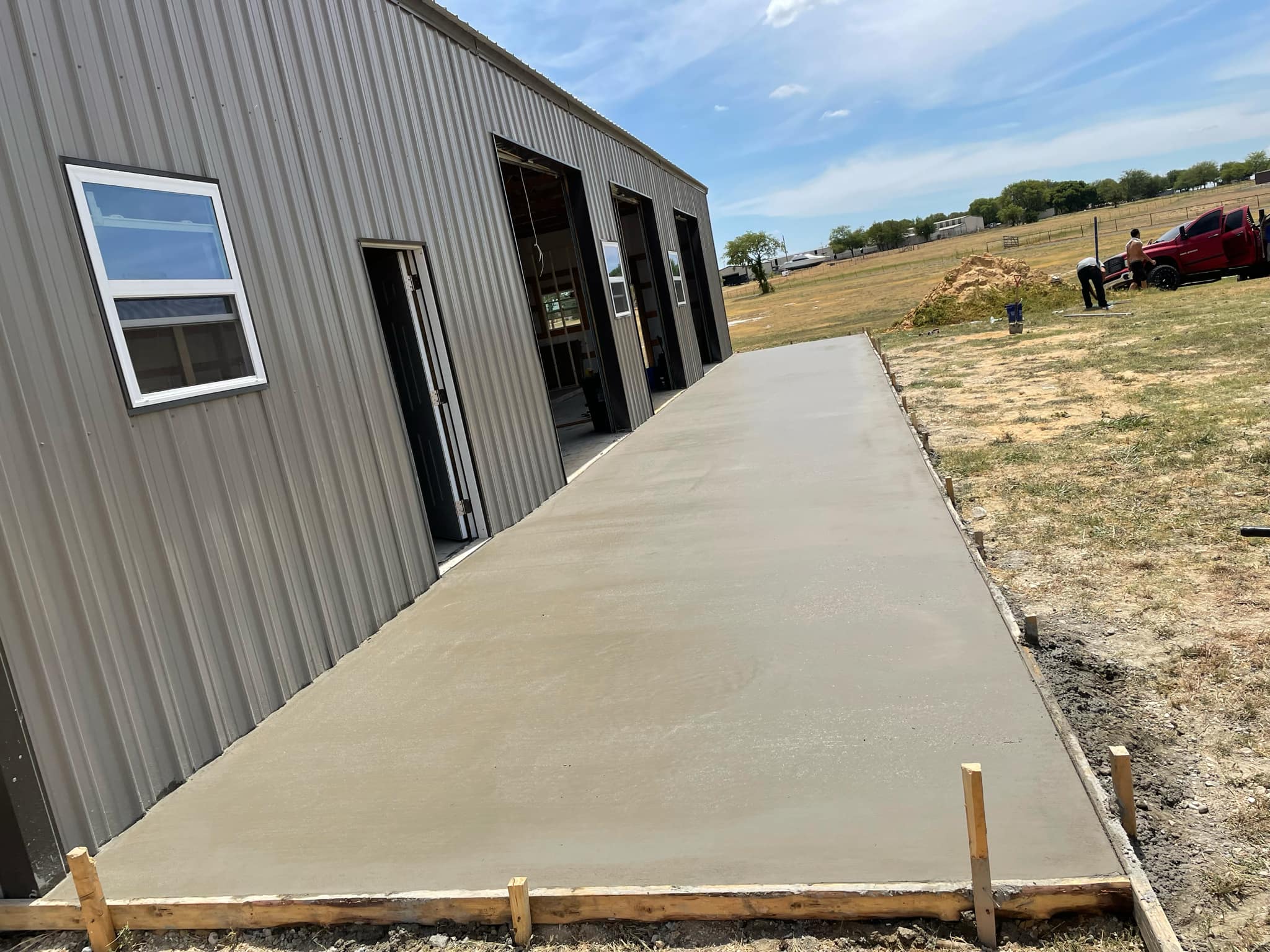 Fresh concrete walkway outside a metal building